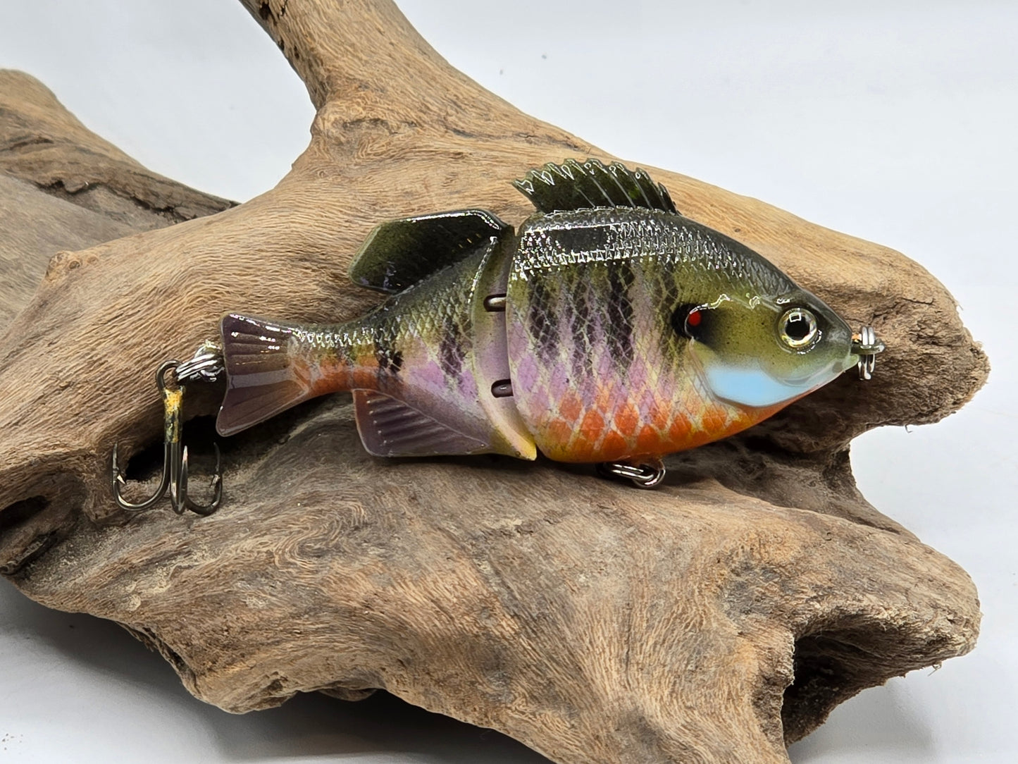 Fishing lure resembling a fish on a piece of wood